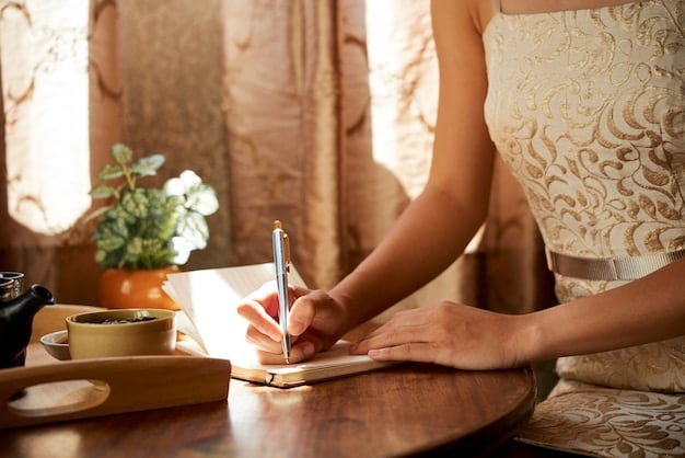 A close-up shot of a hand writing in a journal with the word 
