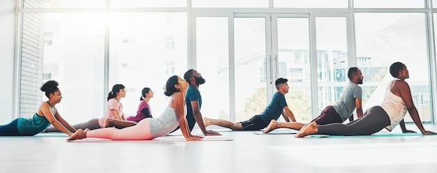 A group of diverse people participates in a yoga class in a bright, airy studio. They are performing various poses, guided by an instructor. The atmosphere is calm and encouraging, promoting wellness and community.