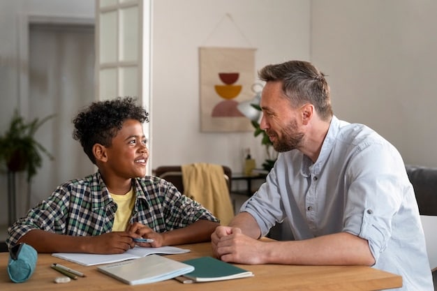 A parent talking to school counselor in a school, while her son sitting nearby.