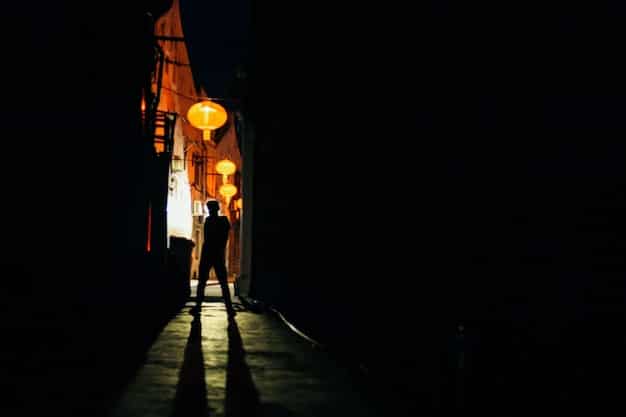 A dimly lit alleyway in Seoul at night, with steam rising from sewers and a lone figure walking away into the shadows, suggesting a sense of mystery and pursuit.