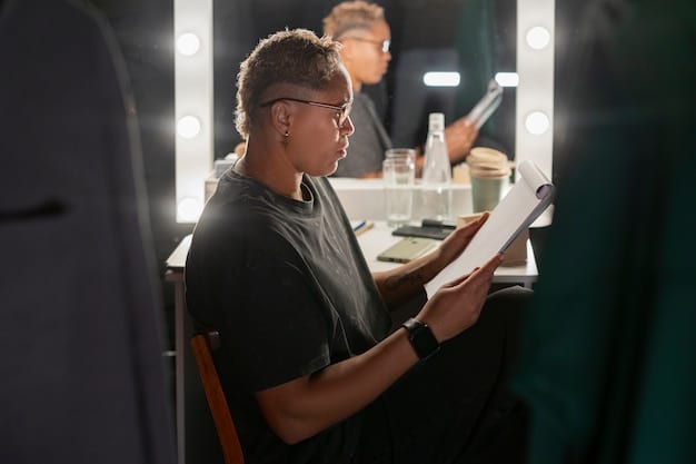 A close-up shot of the director on set, giving instructions to the actors. The atmosphere is intense, with crew members working around and lights illuminating the scene. The focus is on the director's determined expression.